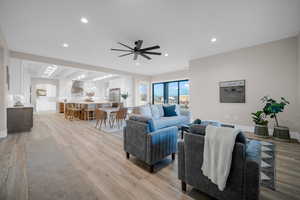 Living room with ceiling fan and light wood-type flooring