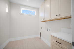 Laundry area featuring cabinets, hookup for a washing machine, and hookup for an electric dryer