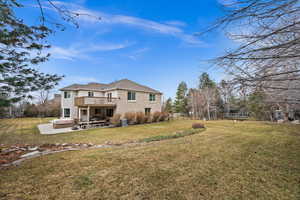 Back of property with a patio, a hot tub, a trampoline, and a lawn