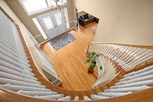 Entrance foyer featuring hardwood / wood-style flooring, a chandelier, french doors, and a high ceiling