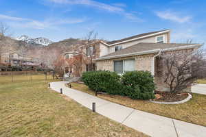 View of front of home with a mountain view and a front lawn