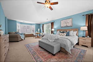 Carpeted bedroom featuring vaulted ceiling and ceiling fan