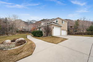 Front facade with a mountain view, a garage, and a front yard