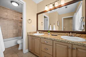 Full bathroom with tile patterned flooring, vanity, shower / bathtub combination with curtain, and toilet