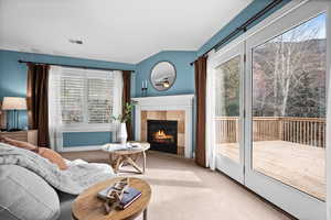 Carpeted living room with a tile fireplace