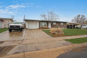 Single story home featuring a garage and a front yard - enhanced grass