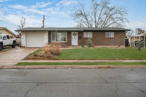 Single story home with a garage and a front yard - Enhanced grass