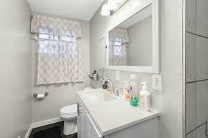 Bathroom featuring vanity, toilet, and hardwood / wood-style floors