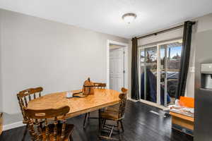 Dining area with dark wood-type flooring and a textured ceiling