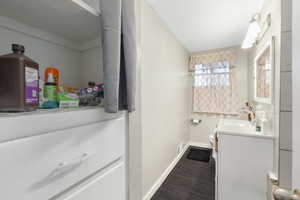 Bathroom featuring hardwood / wood-style flooring, vanity, and toilet