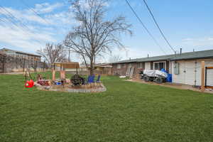 View of yard featuring an outdoor fire pit - enhanced grass