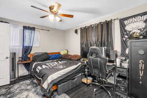 Bedroom featuring dark wood-type flooring and ceiling fan