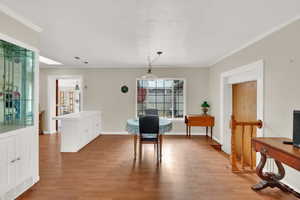 Dining room with ornamental molding and light hardwood / wood-style floors