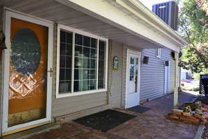 Entrance to property with a patio and central AC unit