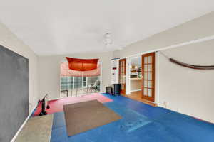 Workout room featuring carpet, ceiling fan, and french doors