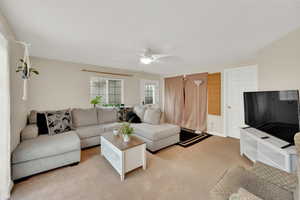 Living room with light carpet and ceiling fan