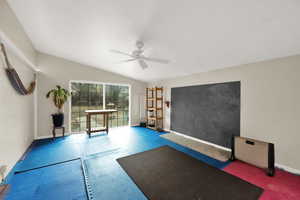 Workout room with lofted ceiling and ceiling fan