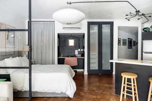 Bedroom featuring refrigerator and a wall unit AC