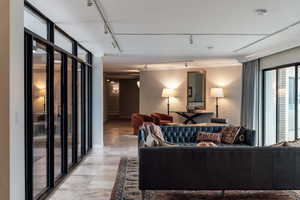 Living room featuring floor to ceiling windows and rail lighting