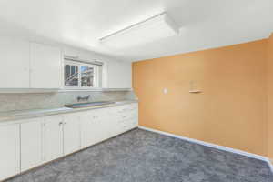 Bedroom or flex/hobby room featuring  sink and white cabinets.