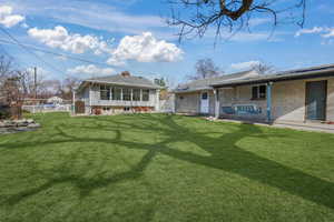 Rear view of property with a yard.