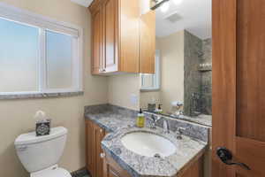 Bathroom with vanity, tiled shower, and good storage.