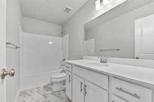 Full bathroom with bathing tub / shower combination, vanity, and toilet