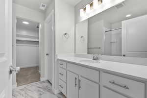 Bathroom featuring vanity and a shower