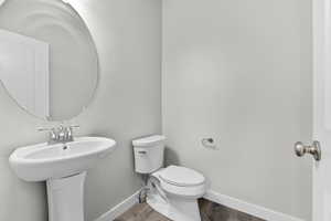 Bathroom featuring sink, wood-type flooring, and toilet