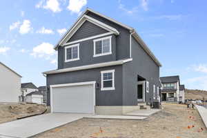 View of front of house featuring cooling unit and a garage