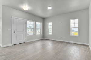 Spare room with light hardwood / wood-style flooring and a textured ceiling