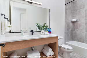 Full bathroom with tile patterned flooring, tiled shower / bath, sink, and toilet