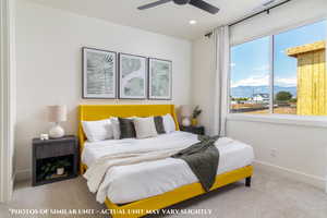 Carpeted bedroom with ceiling fan and a mountain view