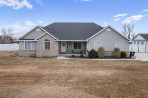 Single story home with a porch and a front yard