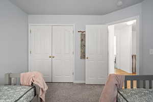 Carpeted bedroom with a closet