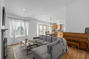 Living room featuring lofted ceiling, a fireplace, light hardwood / wood-style flooring, and a wealth of natural light