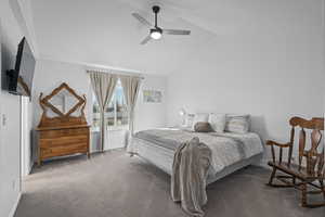 Bedroom with ceiling fan, lofted ceiling, and carpet flooring