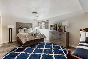 Bedroom with light hardwood / wood-style flooring and a textured ceiling