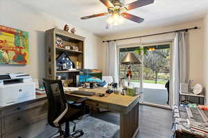 Office space with dark hardwood / wood-style flooring, a textured ceiling, and ceiling fan