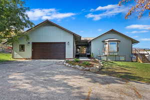 View of front of property featuring a garage and a front yard