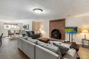 Living room featuring hardwood / wood-style floors, a textured ceiling, and a wood stove