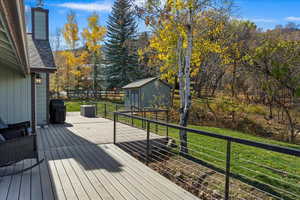 Wooden terrace featuring a shed and a yard