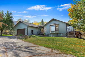 View of front of house with a garage and a front yard