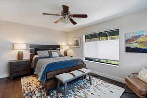 Bedroom with multiple windows, dark wood-type flooring, and ceiling fan