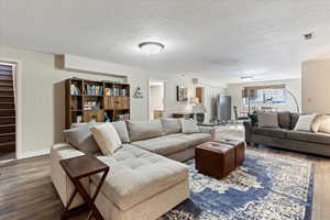 Living room with dark hardwood / wood-style flooring and a textured ceiling