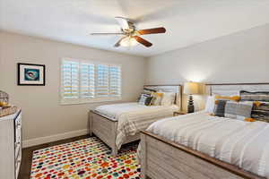 Bedroom with ceiling fan, dark wood-type flooring, and a textured ceiling