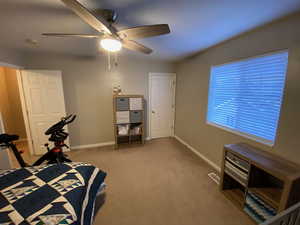 Carpeted bedroom featuring ceiling fan