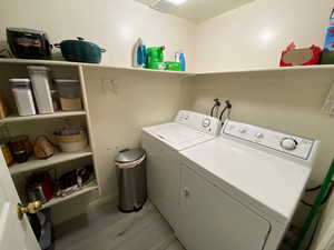 Laundry room featuring light hardwood / wood-style floors and washing machine and clothes dryer