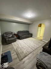 Living room with a textured ceiling and light hardwood / wood-style floors