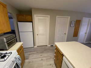 Kitchen featuring white appliances and light hardwood / wood-style flooring